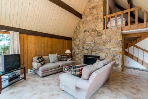 a living room with two couches and a stone fireplace at Clear Water in Shrine Beach