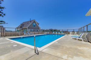 a swimming pool with chairs and a house at Knot a Care in Lincoln City