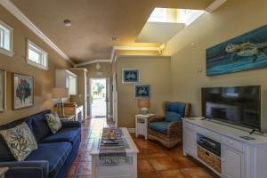sala de estar con sofá azul y TV de pantalla plana en Sunfish 104, en Holmes Beach