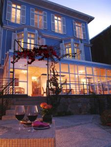 una casa azul con dos copas de vino en Zero Hotel, en Valparaíso