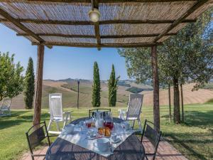 a table under a pergola with a table and chairs at Agriturismo Baccoleno in Asciano