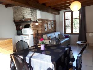cocina y sala de estar con mesa y sillas. en "La Lavandière" Proche des lacs Restauration Netflix et Jacuzzi Parking, en Montmorency-Beaufort