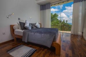 a bedroom with a bed and a large window at Villa Vajrapani in Kandy +84 photos