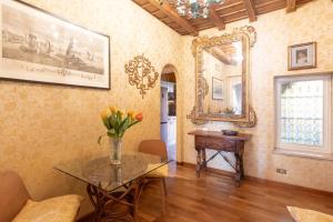 - une salle à manger avec une table et un miroir dans l'établissement Spanish steps casa Nes, à Rome