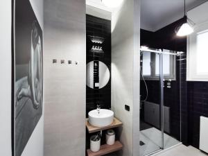 a bathroom with a sink and a glass shower at FLORENTIN Downtown Design Apt in Bergamo +33 photos
