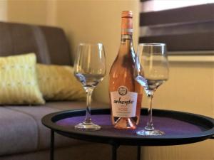 a bottle of wine and two glasses on a table at Cicki Apartments II in Podgorica