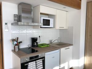 a white kitchen with a sink and a microwave at Résidence Porto Marine in Porto Ota