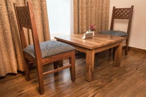 uma mesa de madeira e duas cadeiras com uma mesa de madeira e chairsuggest em Hotel The Yellow em Chandīgarh