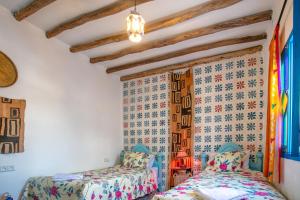 two beds in a room with a wall at Afra House in Chefchaouene