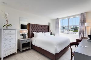 a bedroom with a large bed and a window at Clinton Hotel South Beach in Miami Beach