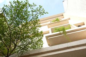 un edificio con algunas plantas a su lado en Backpacker 41 Hostel - Kaohsiung, en Kaohsiung