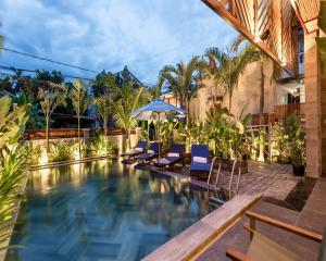 ホイアンにあるTropical Home Villaの椅子とパラソルのあるプール