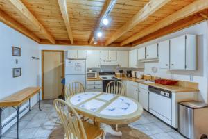 a kitchen with a table and chairs and a wooden ceiling at Treehouse 206F in Silverthorne