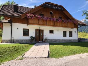 une maison avec un balcon fleuri dans l'établissement Hotel Sogni D'Oro, à Camporosso in Valcanale