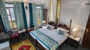 Schlafzimmer mit einem Bett mit blauen Vorhängen in der Unterkunft Chandralok Villa in Udaipur