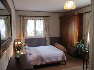- une chambre avec un lit, une armoire et des fenêtres dans l'établissement La Madeleine, à Pezens