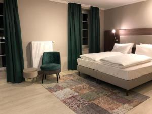 um quarto com uma cama e uma cadeira verde em Arthotel ANA Liberty Bremen City em Bremen