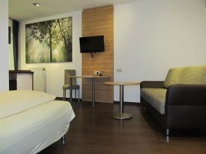 ein Zimmer mit einem Bett, einer Couch und einem Tisch in der Unterkunft Zum Treppche Hotel Garni in Gladenbach