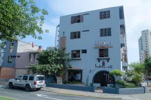 una camioneta blanca estacionada frente a un edificio en Inkawasi Miraflores Hostel, en Lima