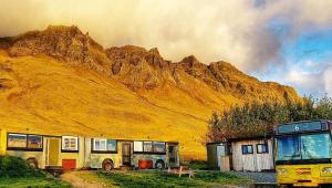 a bus parked next to a building and a mountain at Esjan in Kjalarnes