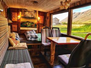 una habitación con una mesa y sillas en un tren en Esjan, en Kjalarnes