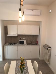 a kitchen with white cabinets and a table and a sink at Affittacamere Badia in Foligno +17 photos