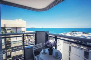 a balcony with a table and a view of the ocean at Seaview Penthouse Arpoador in Rio de Janeiro