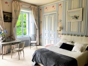 una camera con letto, scrivania e finestra di Les chambres d'hôtes du Manoir de Roz-Maria a Quintin