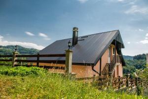 una piccola casa con un tetto nero su una collina di Forest Paradise - four bedroom villa a Kolašin