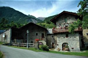 a stone building with a balcony on the side of a road at La Maison Everest 73 - bilocale a La Ruine, Morgex in Morgex