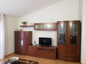 a living room with a tv and wooden furniture at Apartamento turístico Amantes in Teruel