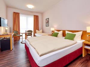 a hotel room with a large bed and a desk at AKZENT Hotel Turmwirt ***S in Oberammergau