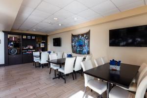 una sala da pranzo con tavoli neri e sedie bianche di SEVEN Sebring Raceway Hotel a Sebring