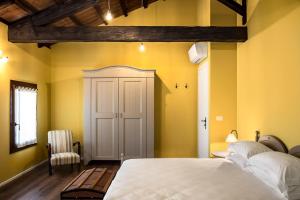 um quarto com uma cama branca e paredes amarelas em Ca' Ciaran em Chiarano