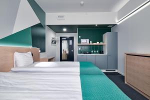 Un dormitorio con una cama grande y una pared verde en GreenStar Hotel Jyväskylä, en Jyväskylä