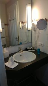 a bathroom with a sink and a mirror at Dreimädelhaus - Kirchseelte in Kirchseelte