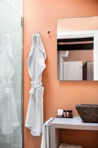 uma casa de banho com um chuveiro e um roupão branco em Ca' Ciaran em Chiarano