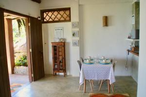 Un comedor con una mesa y sillas y una puerta. en Casinha romantica frente para o mar, en Ilhabela 43 fotos más