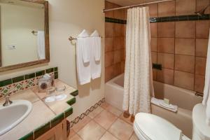 a bathroom with a sink and a tub and a toilet at Inn on the Alameda in Santa Fe