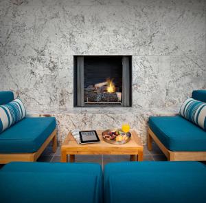 a living room with blue couches and a fireplace at The Lumen in Dallas