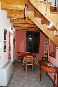 uma sala de jantar com uma mesa e um tecto de madeira em Etna Casa Llera-Antica casa siciliana em Milo