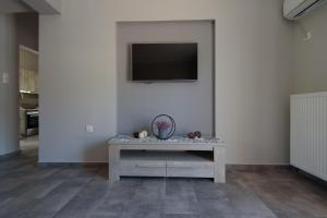 a room with a table with a tv on a wall at Andriana' s apartment Agia Paraskevi in Athens