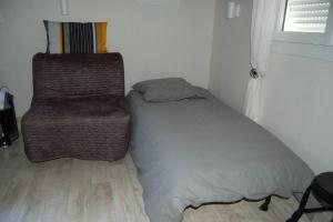 1 cama y 1 silla en una habitación en Gite Millesime Proche St Emillion, en Abzac