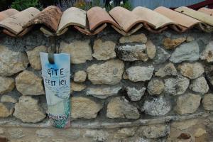 Una pared de piedra con un cartel. en Gite Millesime Proche St Emillion, en Abzac