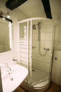 a white bathroom with a shower and a sink at Hotel Gasthaus Papen Änne in Kassel