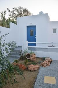 a house with a blue door and some rocks at Blue Paradise Apartments in Naxos Chora