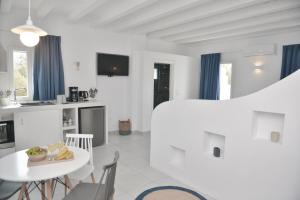 a white room with a white table and a kitchen at Blue Paradise Apartments in Naxos Chora