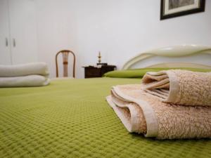 zielone łóżko z kocem na górze w obiekcie Holiday Home Sferracavallo w mieście Palermo