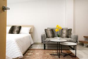 a bedroom with a bed and a couch and a table at Apartments and Rooms Distecon in Guatemala +94 photos