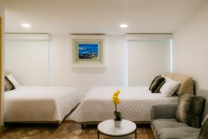 Apartments and Rooms Distecon في غواتيمالا: غرفة معيشة بها سريرين وأريكة